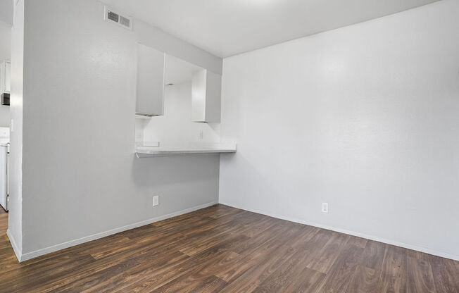 an empty living room with white walls and wood floors