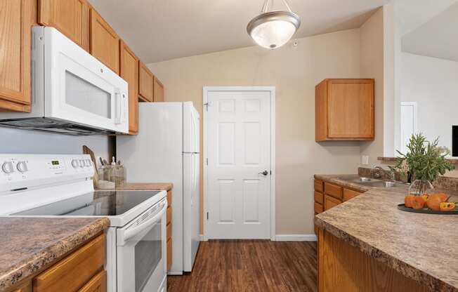 a kitchen with white appliances and wooden cabinets