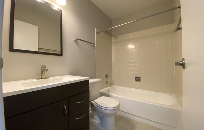 Bathroom with vanity storage and a full tub
