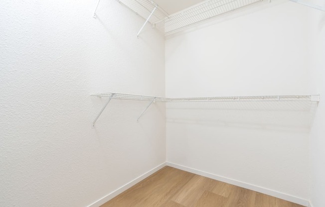 an empty room with white walls and a wood floor