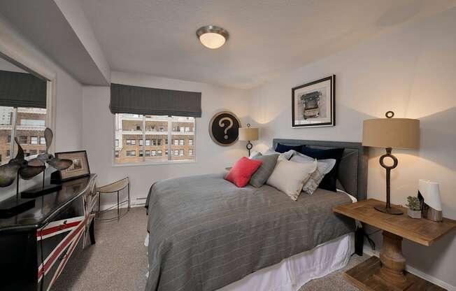 A bedroom with a bed, a desk, and a chair