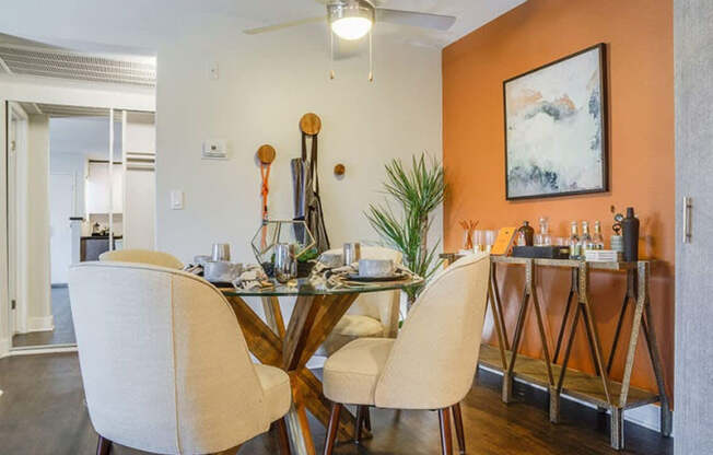 A dining room with a glass table and chairs.
