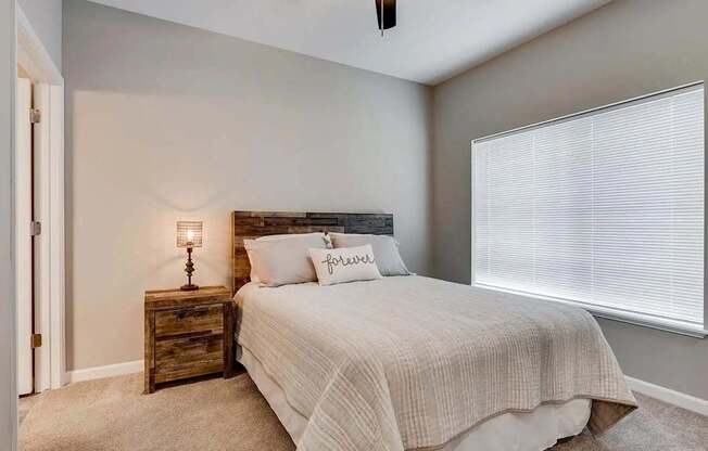 a bedroom with a bed and a window.  Circle Pines, MN Lexington Lofts