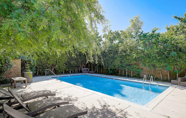 a swimming pool with two chairs next to it