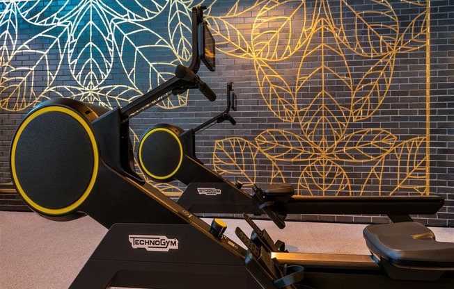 a treadmill in front of a mural of leaves