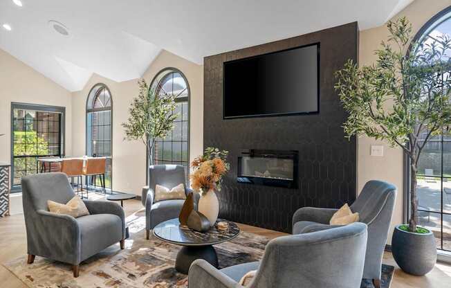 A living room with grey chairs and a black television.