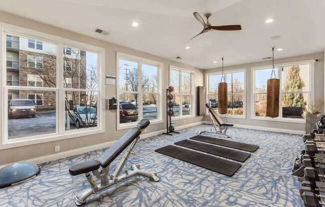 A spacious gym with a variety of equipment including a bench press, a rowing machine, and a treadmill.
