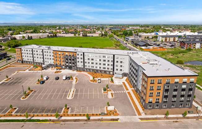 A large multi-story building with a parking lot in front.