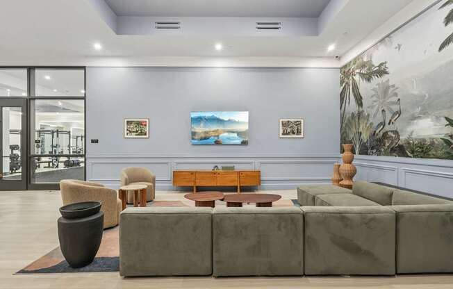 A living room with a grey couch, a brown coffee table, and a large vase.