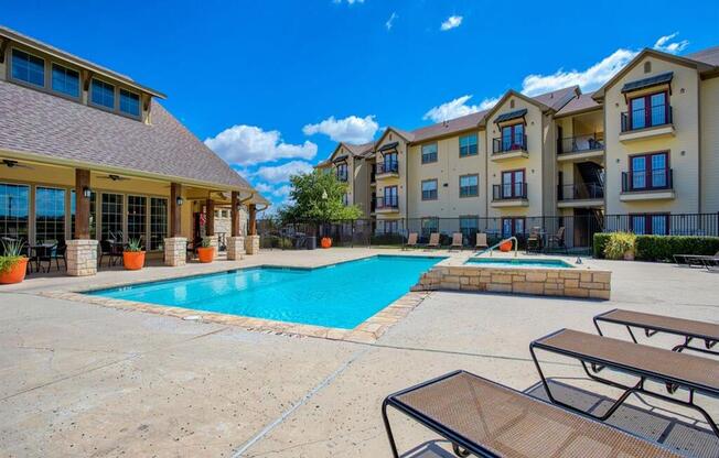 Swimming pool at Oak hollow with beach chairs and exterior building