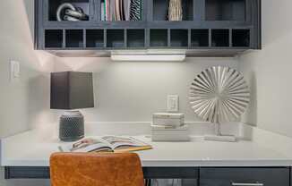 a small desk with a chair and a black cabinet