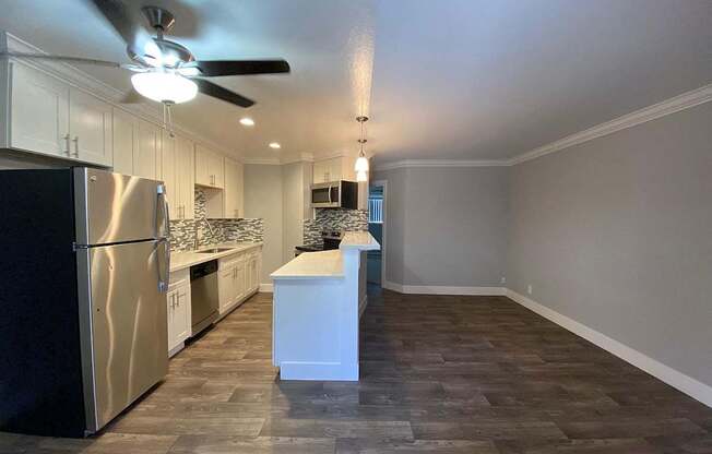 A kitchen with a refrigerator, sink, and countertop.