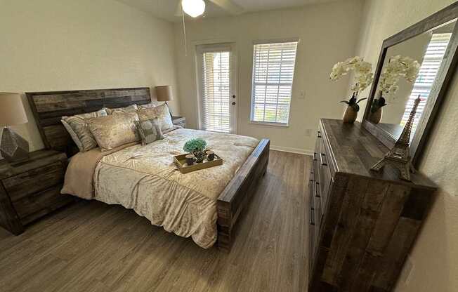 A bedroom with a bed, dresser, and mirror.