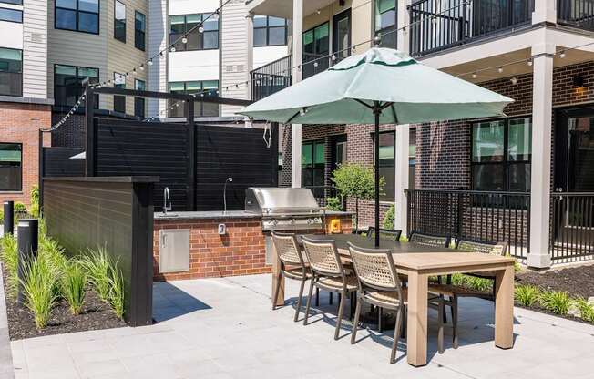 A patio with a table and chairs under an umbrella.