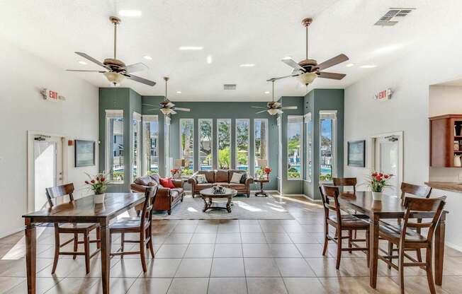 A dining room with a table surrounded by chairs and a ceiling fan.