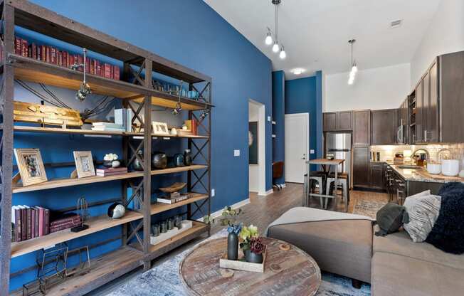 a living room with blue walls and a kitchen with a table