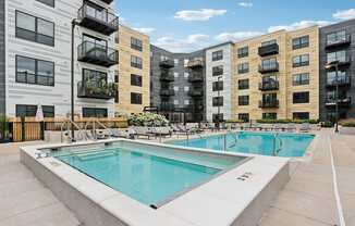 A swimming pool in front of apartment buildings.