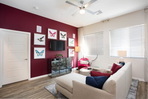 a living room with a red accent wall and a white couch