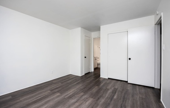 an empty living room with white walls and wood flooring