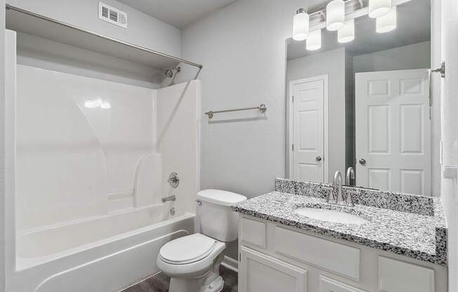 A white bathroom with a toilet, sink, and bathtub.
