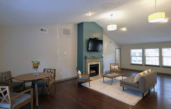 a living room with a fireplace and a table and chairs