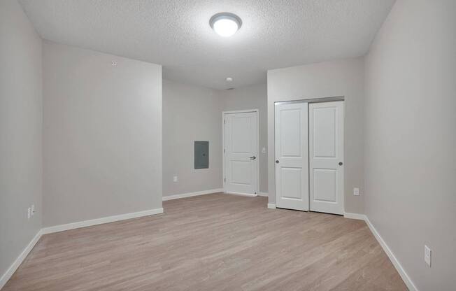 A room with a white door and a white closet.