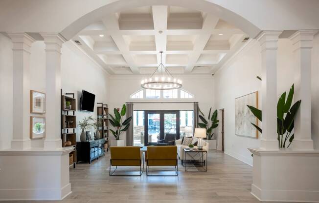 a large living room with white walls and a ceiling with a chandelier