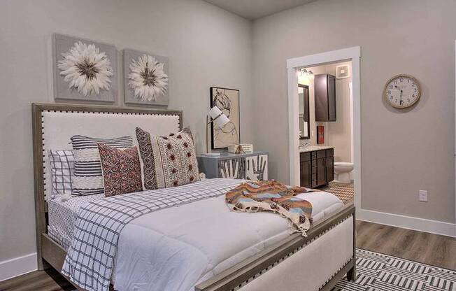 a bedroom with a bed and a clock on the wall at Hunters Creek Apartments, Denton, TX 76210