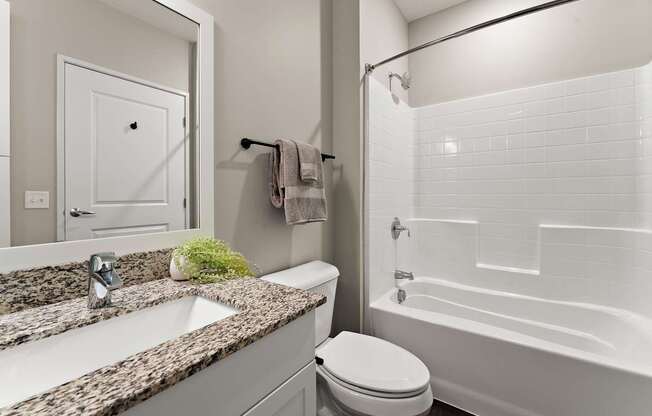 A white toilet sits next to a sink in a bathroom.