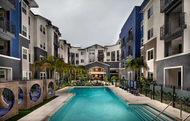 A swimming pool in the middle of a courtyard surrounded by buildings.