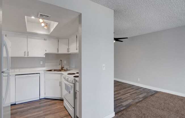 an empty kitchen with white appliances and white cabinets