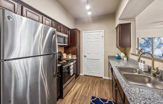 A kitchen with a stainless steel refrigerator and a white door.at The Equestrian by Picerne, Henderson, NV