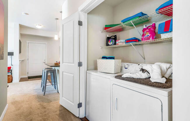 a laundry room with white cabinets and shelves and a white washer and dryer at Mullan Reserve Apartments, Missoula Montana