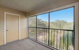 a balcony with a door and a view of some trees and a door to a