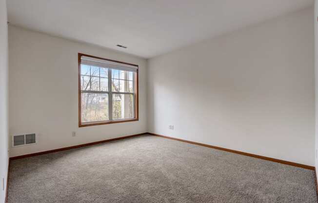 an empty room with carpet and a window