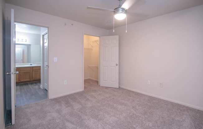 an empty bedroom with a closet and a bathroom