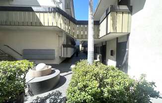 Courtyard view of mailbox, landscape, water feature, and walkways at Parc Meridien, California, 90020