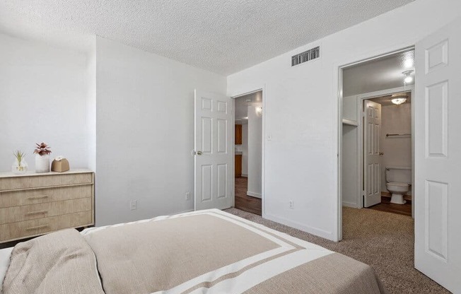 Model Bedroom with Carpet and attached Bathroom at District at Fiesta Park Apartments located in Mesa, AZ.