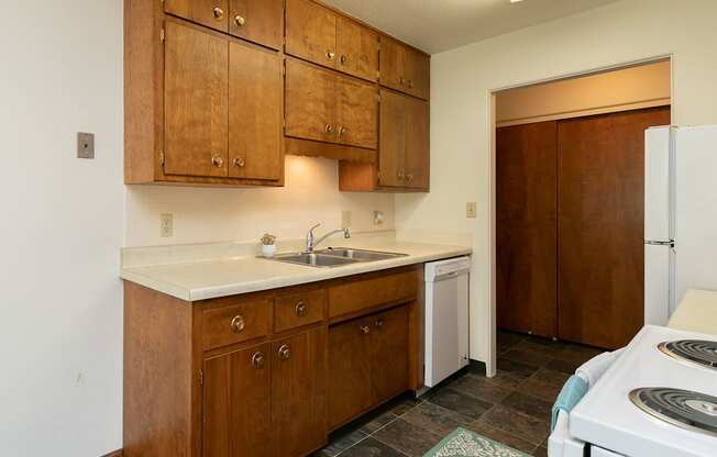 a kitchen with white appliances and wooden cabinets. Fargo, ND Islander Apartments