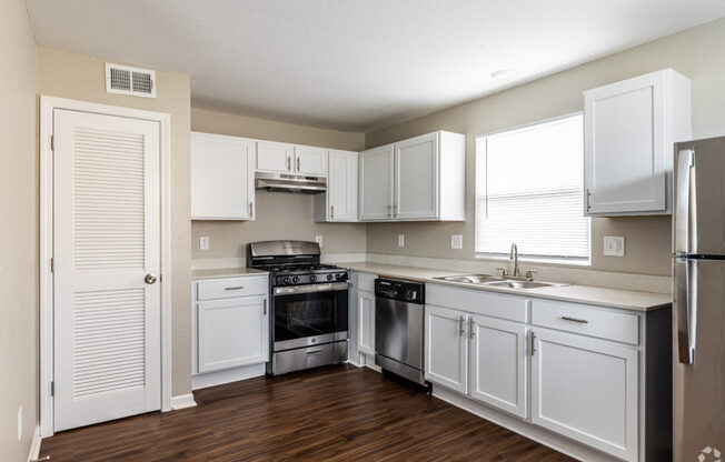 A kitchen with white cabinets and appliances.