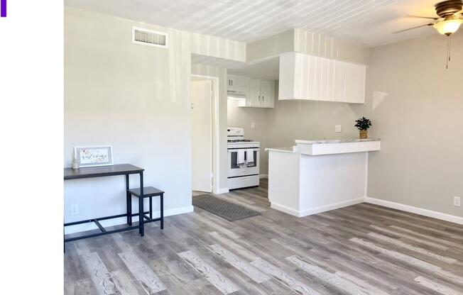 an empty living room with a kitchen in the background at South Pointe Apts, Covina California