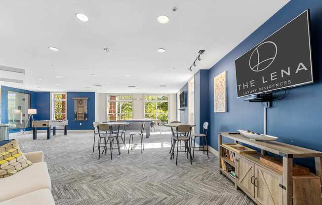 a common room with a tv and tables and chairs  at The Lena, New Jersey