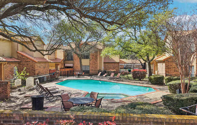 A pool surrounded by trees and chairs.
