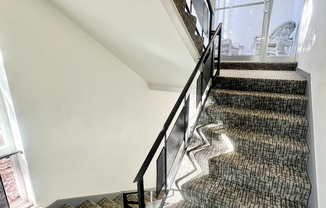 Step into elegance with this well-lit stairway, offering style and comfort.