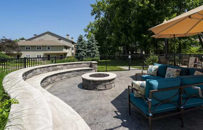 A patio with a fire pit and a blue couch.
