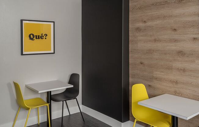 a room with two tables and two chairs with a yellow sign on the wall that says quiz