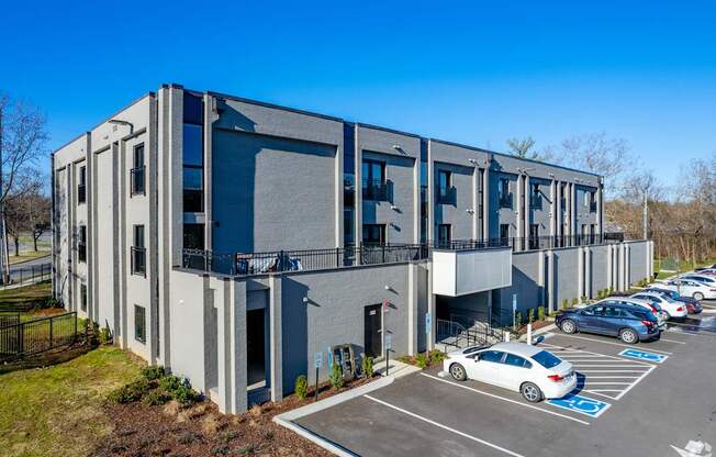 A modern building with a parking lot in front.