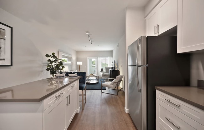 A modern kitchen with white cabinets and a black refrigerator.