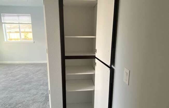 A white door with a black frame is open to a room with a carpeted floor.