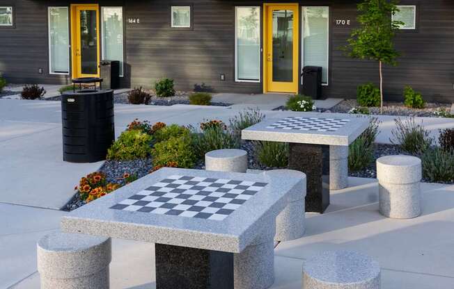 A chess board is set up on a table outside a building.